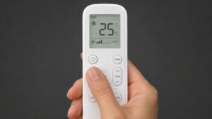Person using an air conditioner remote set to cooling mode at 25 degrees Celsius.