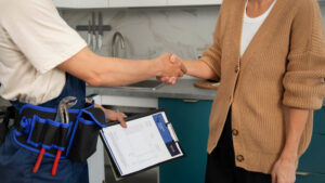 Plumber shaking hands with a homeowner after completing a home service visit.