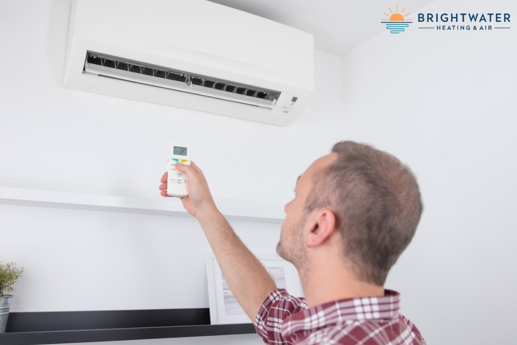 Homeowner using a mini-split remote while following a checklist before turning on the heater in Orange County.